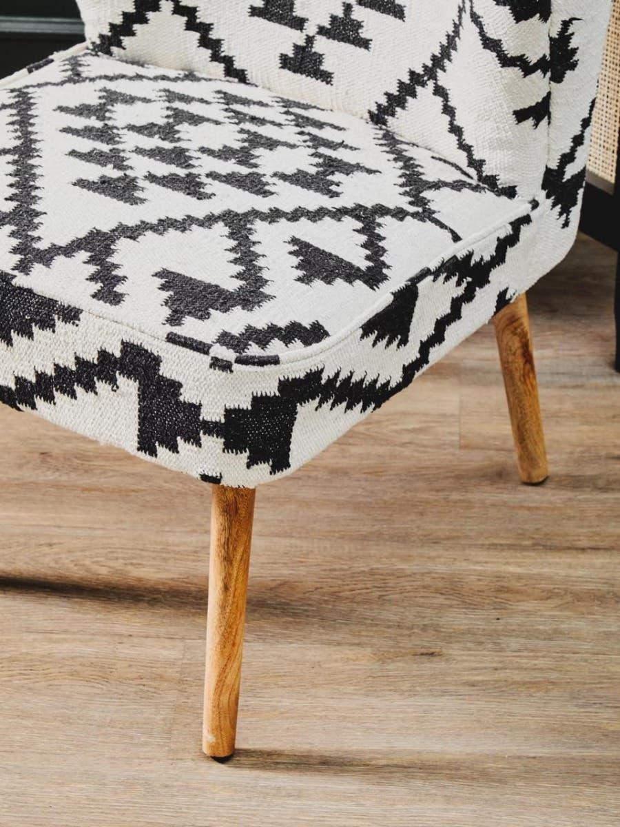 Black and white patterned accent chair with wooden legs on oak floor