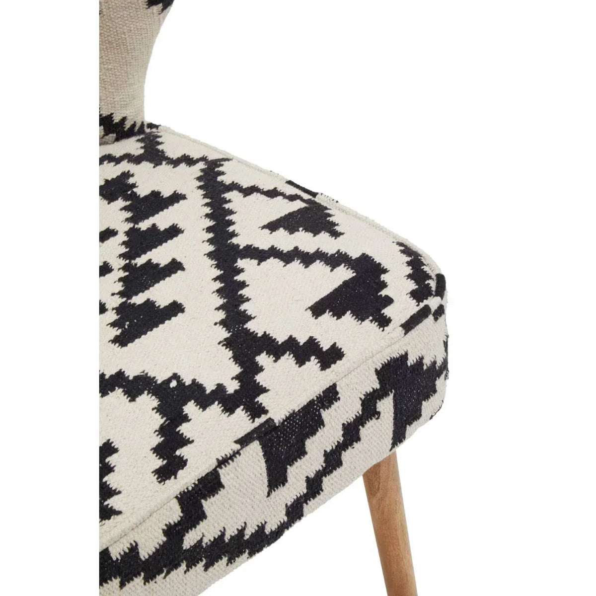 Dining chair with black and cream geometric upholstery and wooden legs, side angle view