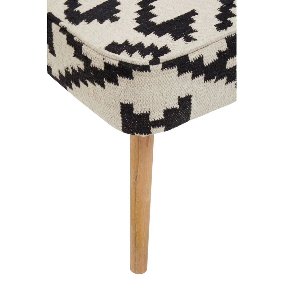 Corner of upholstered bench with black and white geometric pattern and wooden leg
