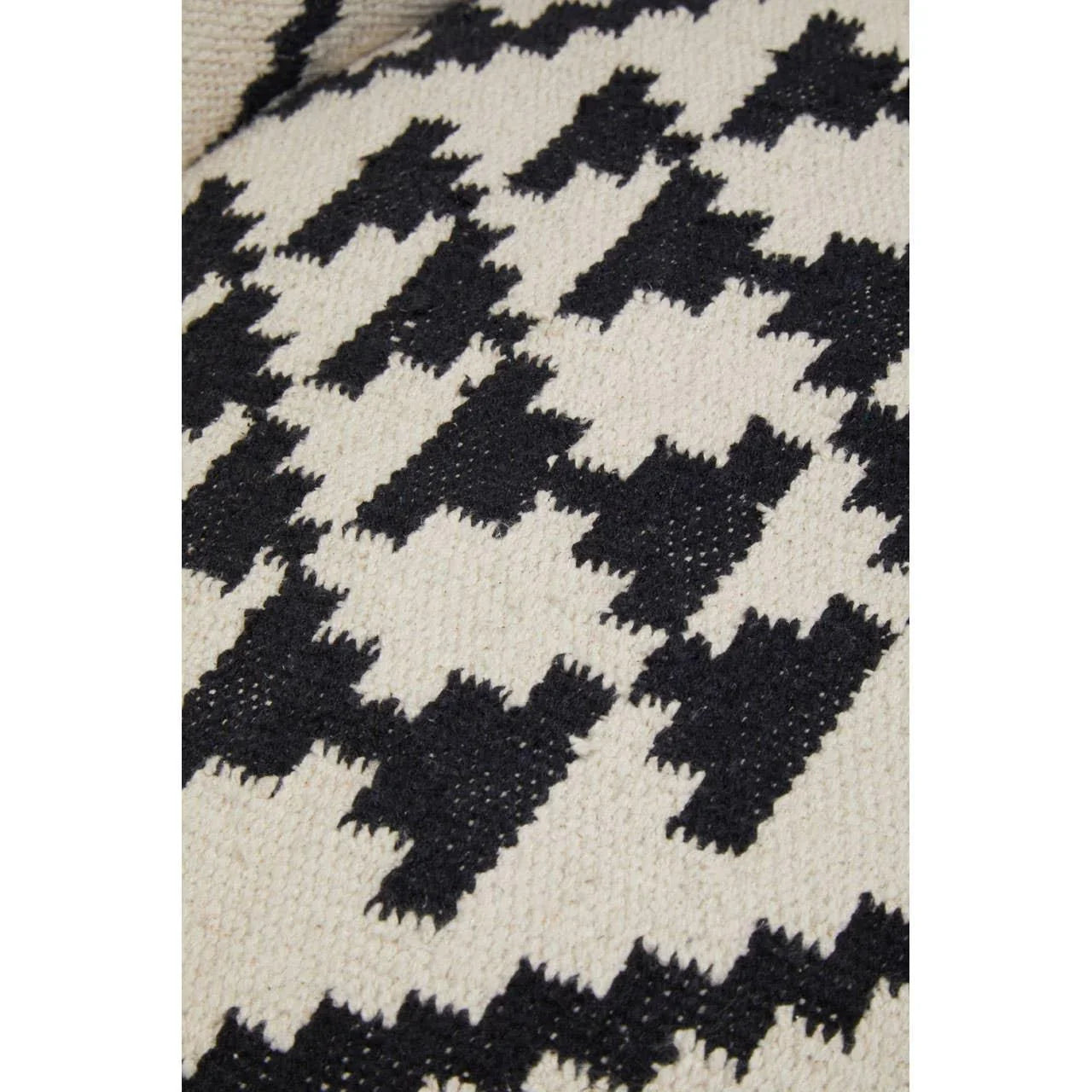 Black and cream woven rug with geometric houndstooth pattern close-up