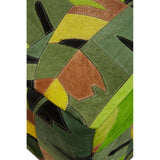 A colorful pouffe featuring a botanical design with various shades of green, yellow, and brown, showcasing a patchwork of leaf patterns on a leather surface