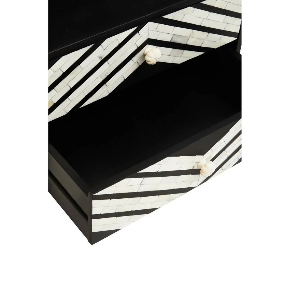 Black and white striped chest of drawers with geometric inlay and round knobs, close view