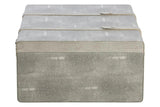 Grey faux shagreen storage trunk with two straps and textured finish, front view