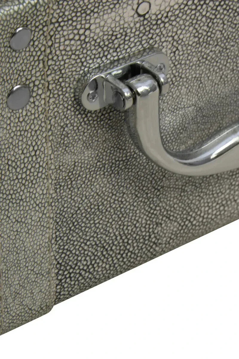 Close-up of faux shagreen storage trunk with textured grey finish and chrome handle