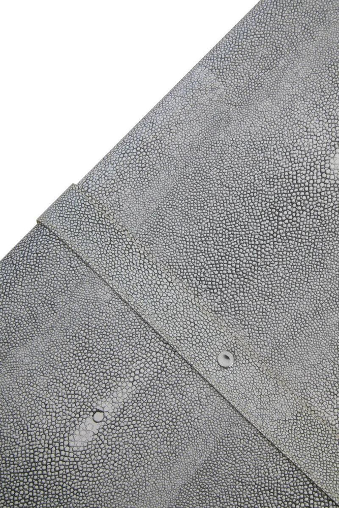 Closeup of grey textured faux shagreen furniture surface with metal rivet detail