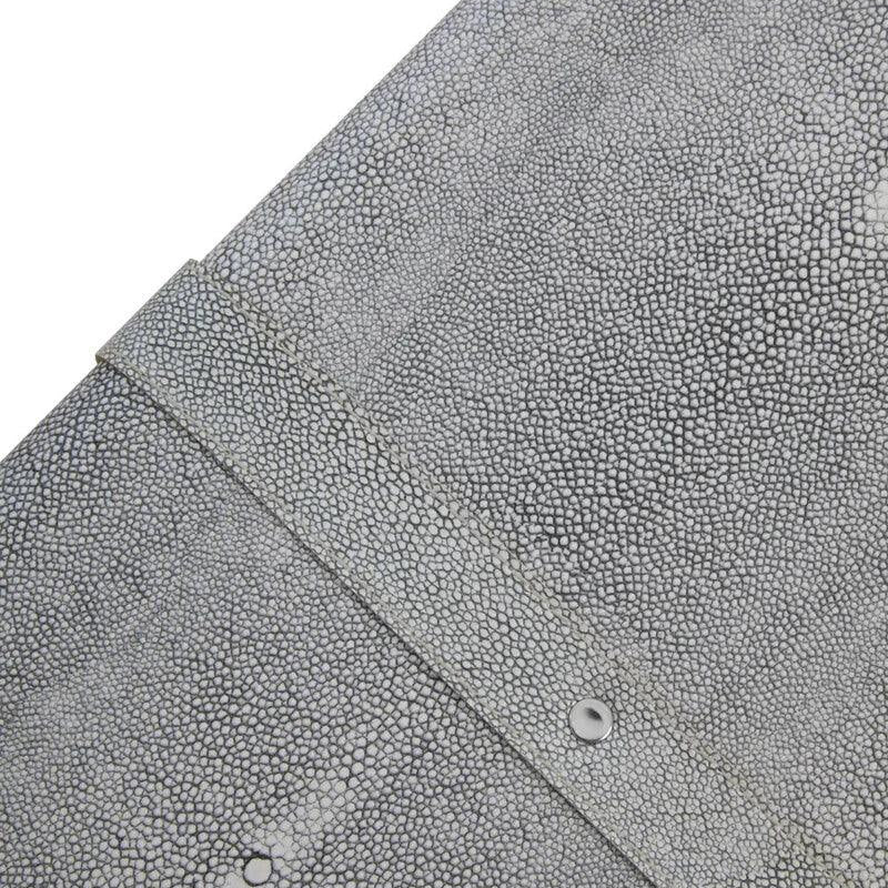Closeup of grey textured faux shagreen furniture surface with metal rivet detail