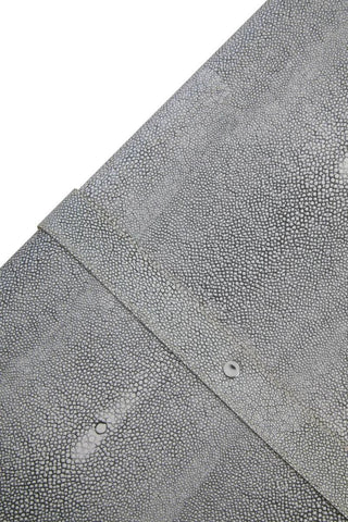 Closeup of grey textured faux shagreen furniture surface with metal rivet detail