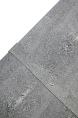 Closeup of grey textured faux shagreen furniture surface with metal rivet detail