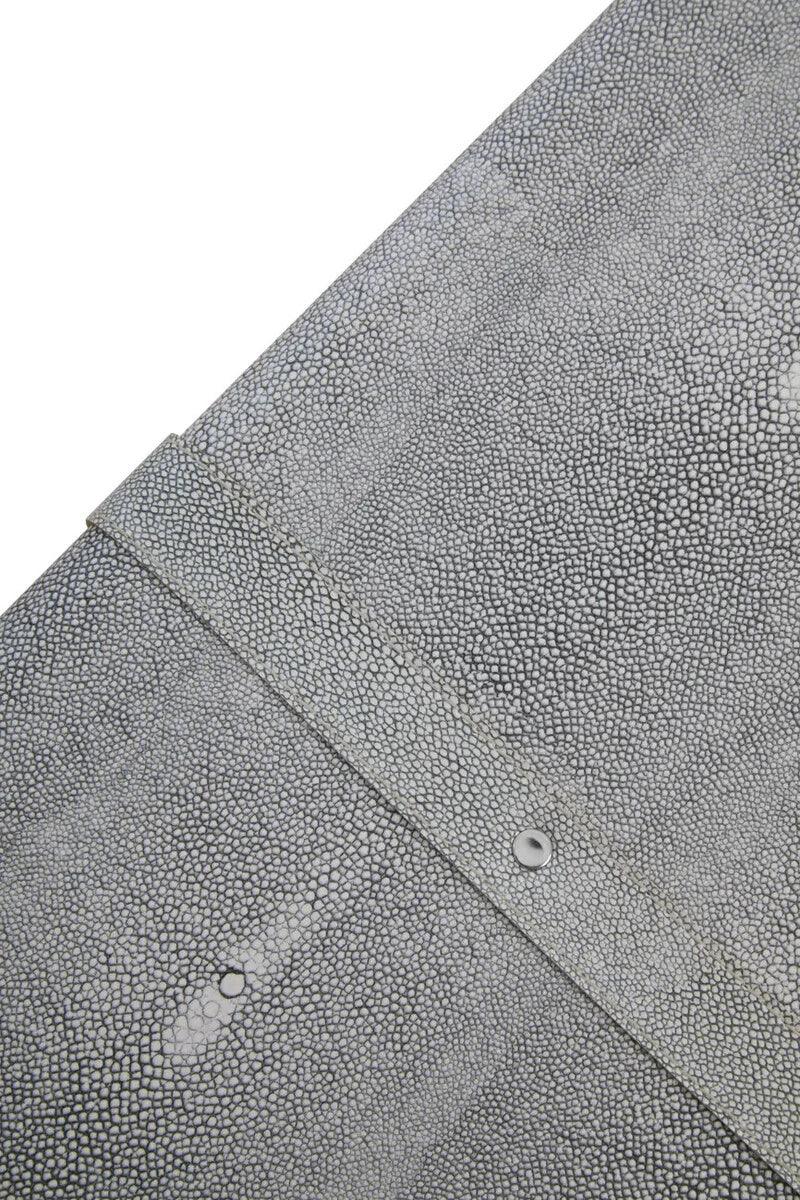 Closeup of grey textured faux shagreen furniture surface with metal rivet detail