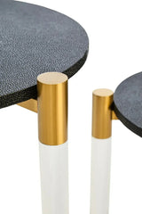 Closeup of round nesting tables with black textured tops and gold metal legs