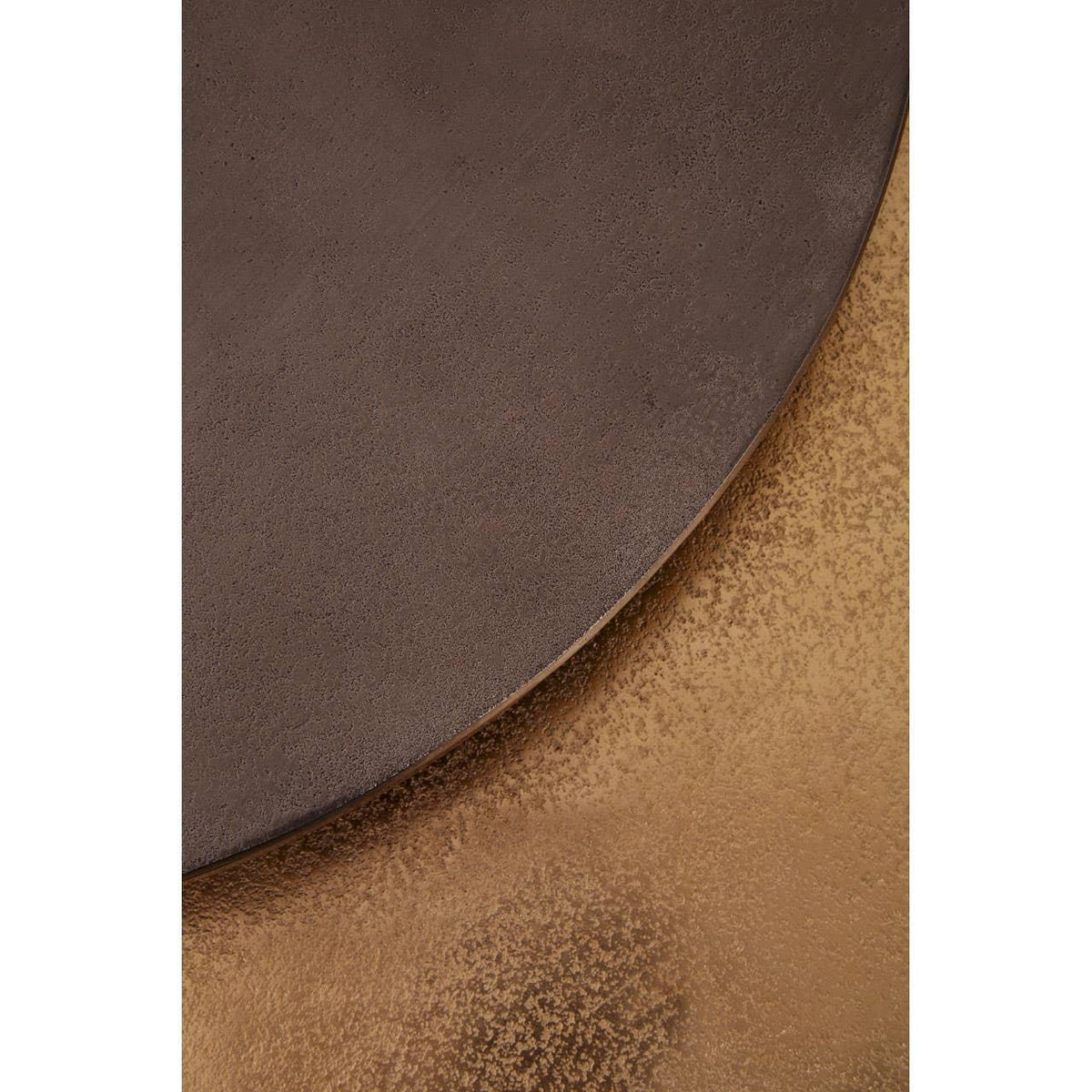 Close up of round bronze coffee table top with textured metallic finish