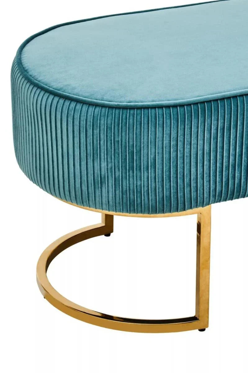 Teal velvet ottoman with pleated sides and gold metal base, showing close detail view