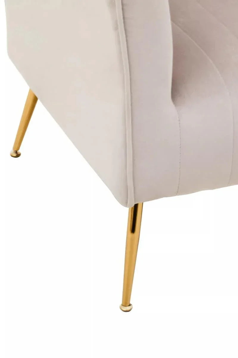 Beige velvet armchair corner with gold metal tapered legs close-up