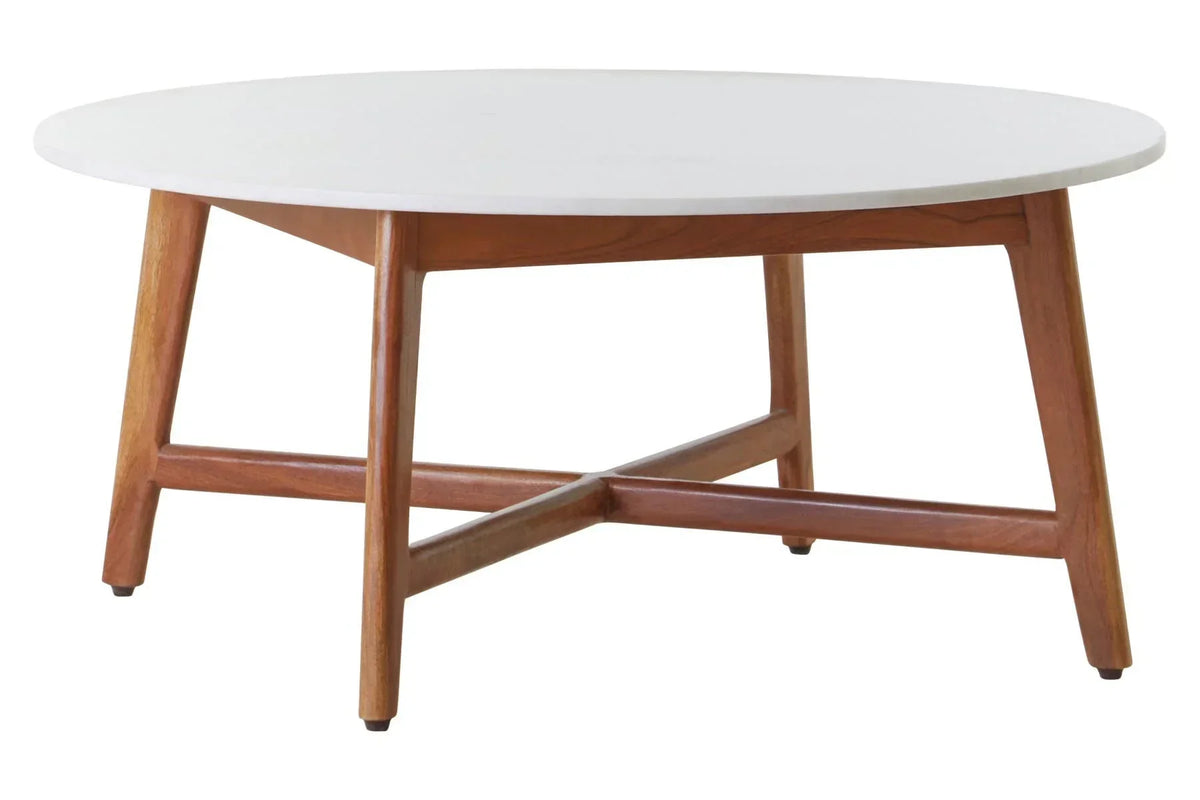 Round coffee table with white top and wooden legs, angled view