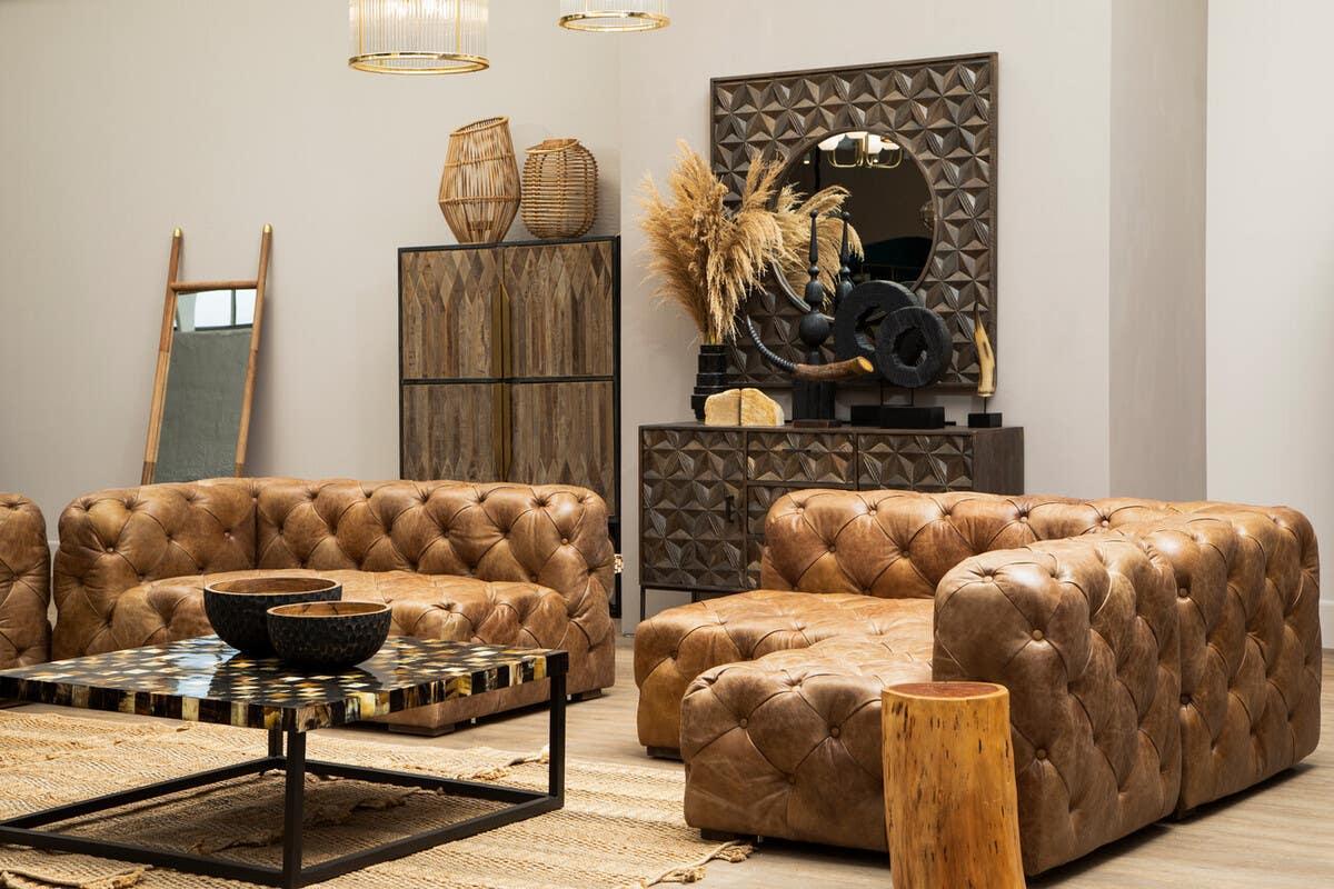 Brown leather Chesterfield sofas with tufted design, wooden coffee table, modern living room decor