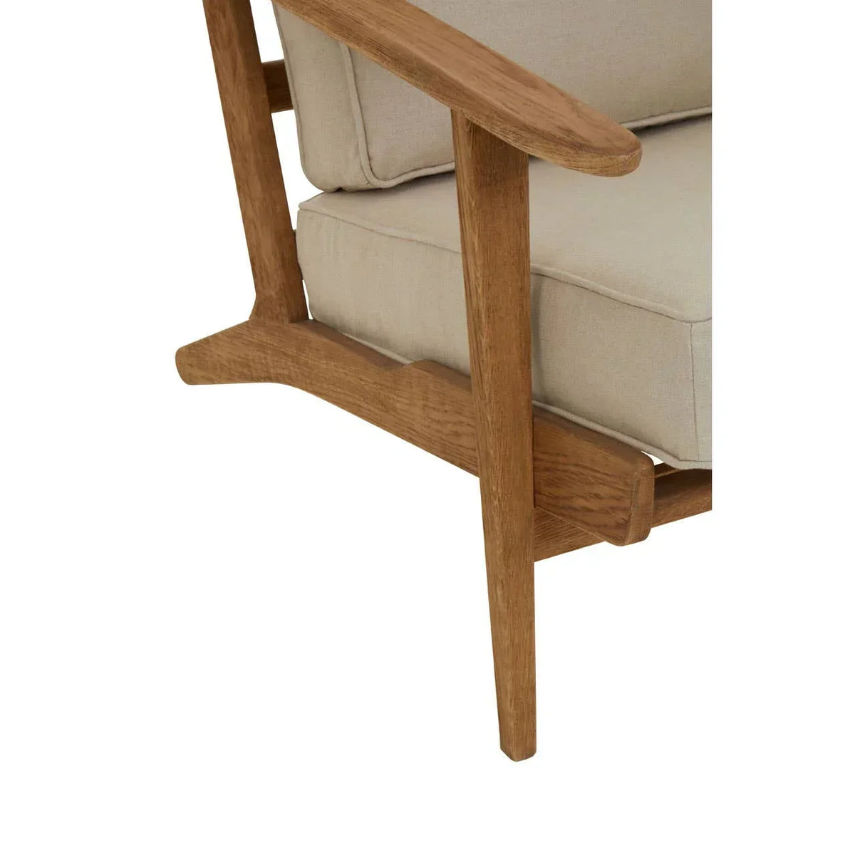 Close-up of wooden armchair leg with beige fabric cushion