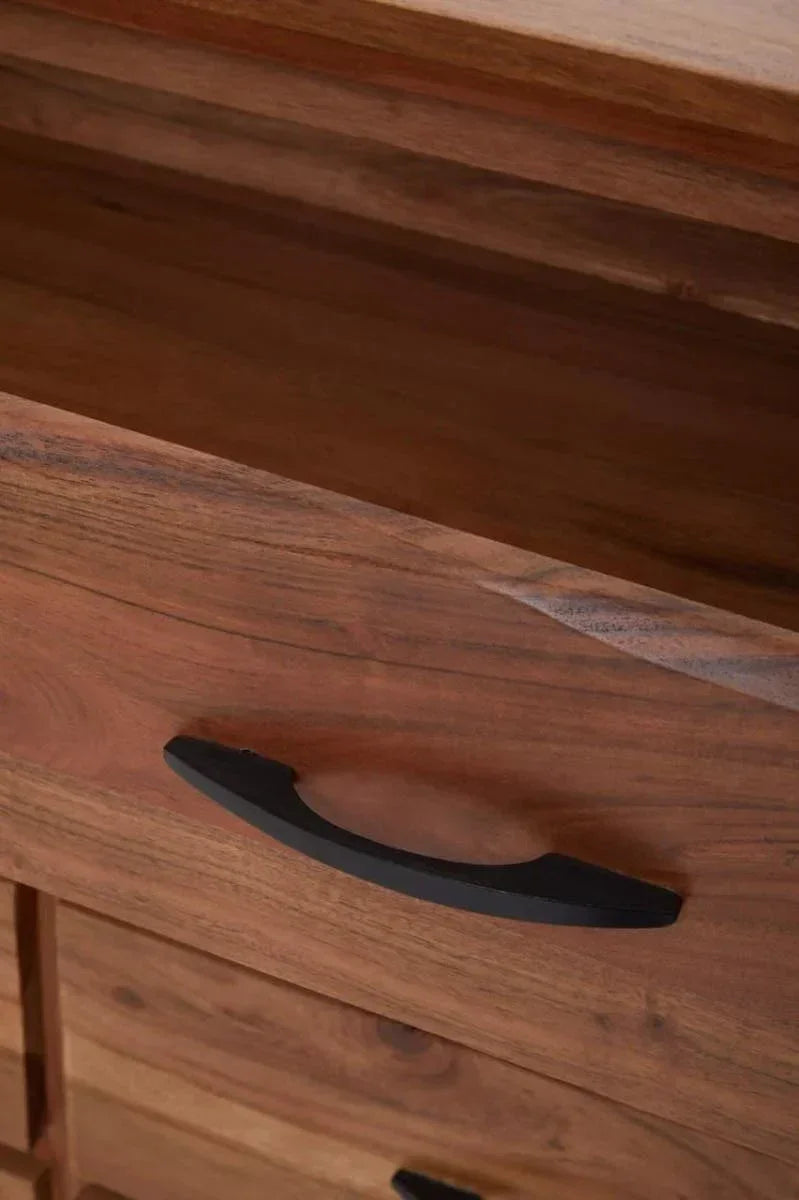 Closeup of wooden chest of drawers with black metal handle and natural grain finish