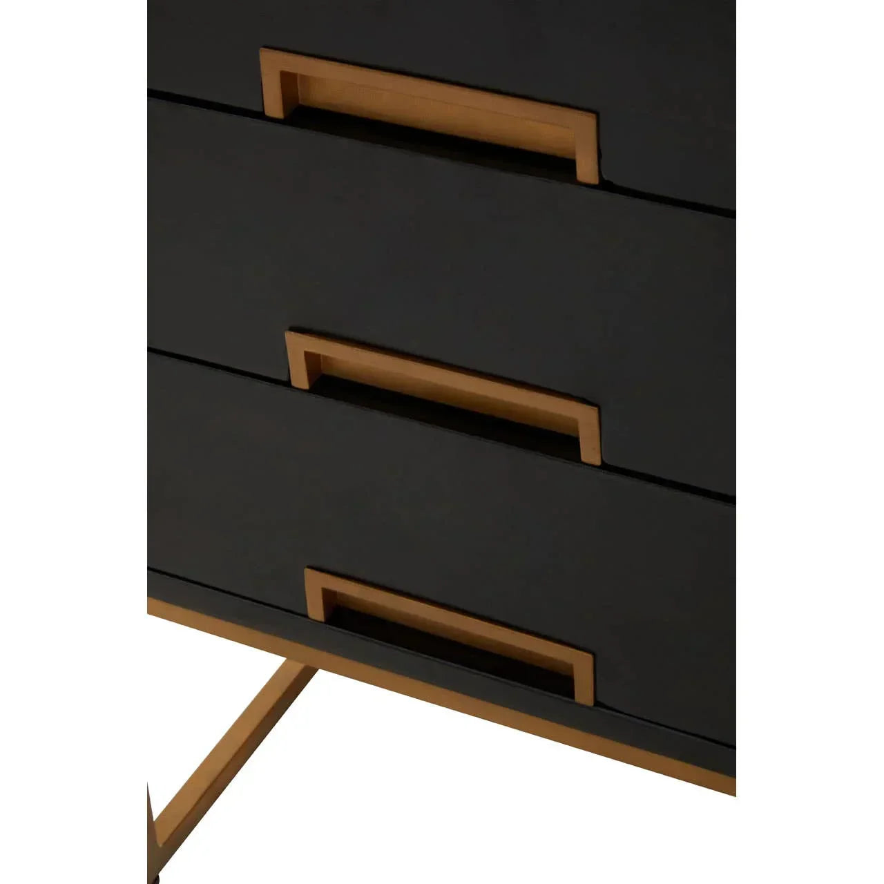 Close-up of black chest of drawers with gold handles and gold leg support
