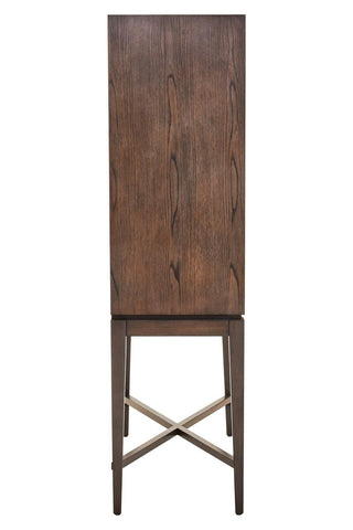 Tall antique grey cabinet with a smooth, flat front and a wooden texture, featuring a simple design and a cross-braced base for stability. The cabinet stands on slender legs, showcasing a minimalist aesthetic suitable for various home decor styles