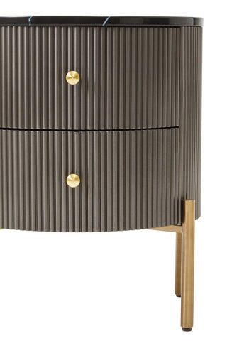 Grey two-drawer chest featuring a black marble top, ribbed texture on the drawer fronts, and gold round handles. The chest stands on slender gold legs, adding a modern touch to the design