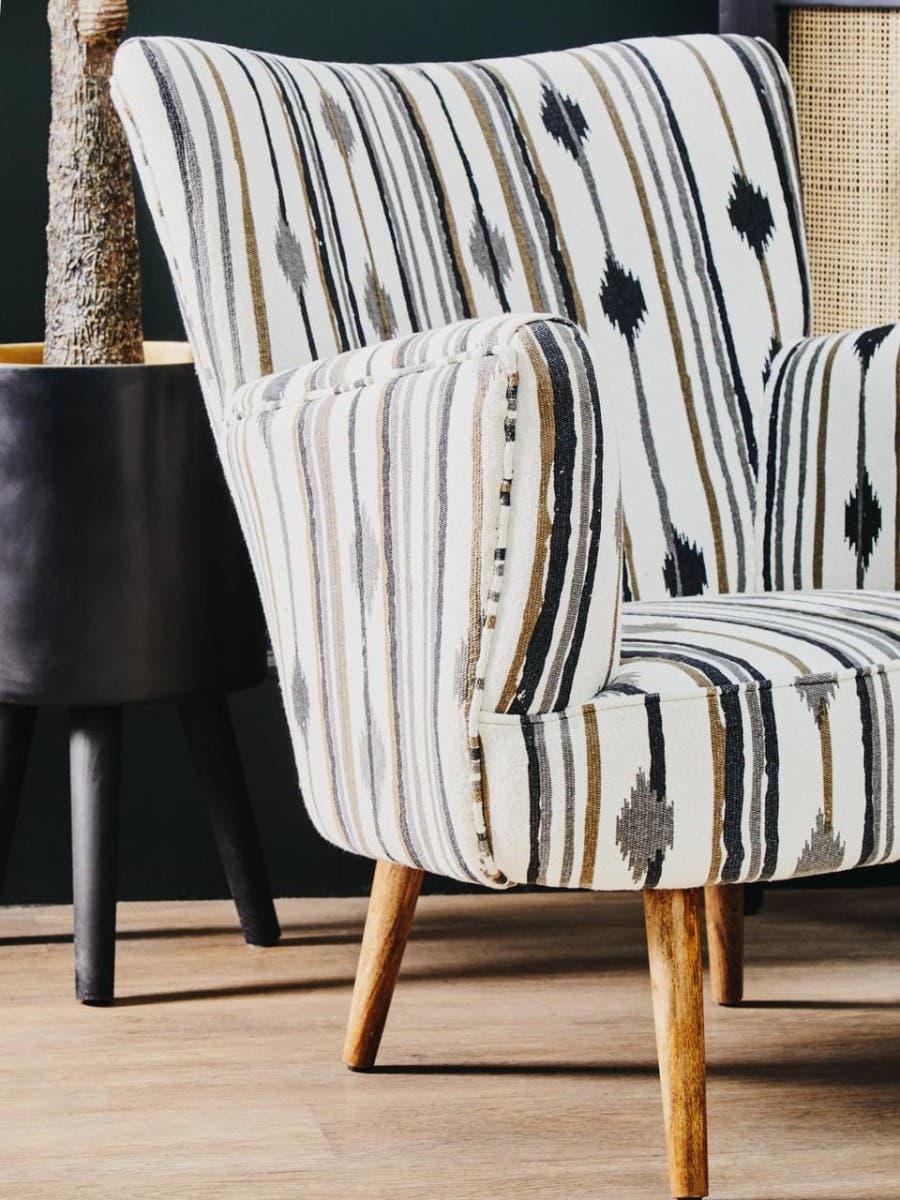 Striped accent chair with wooden legs and beige, black, and gold upholstery in living room