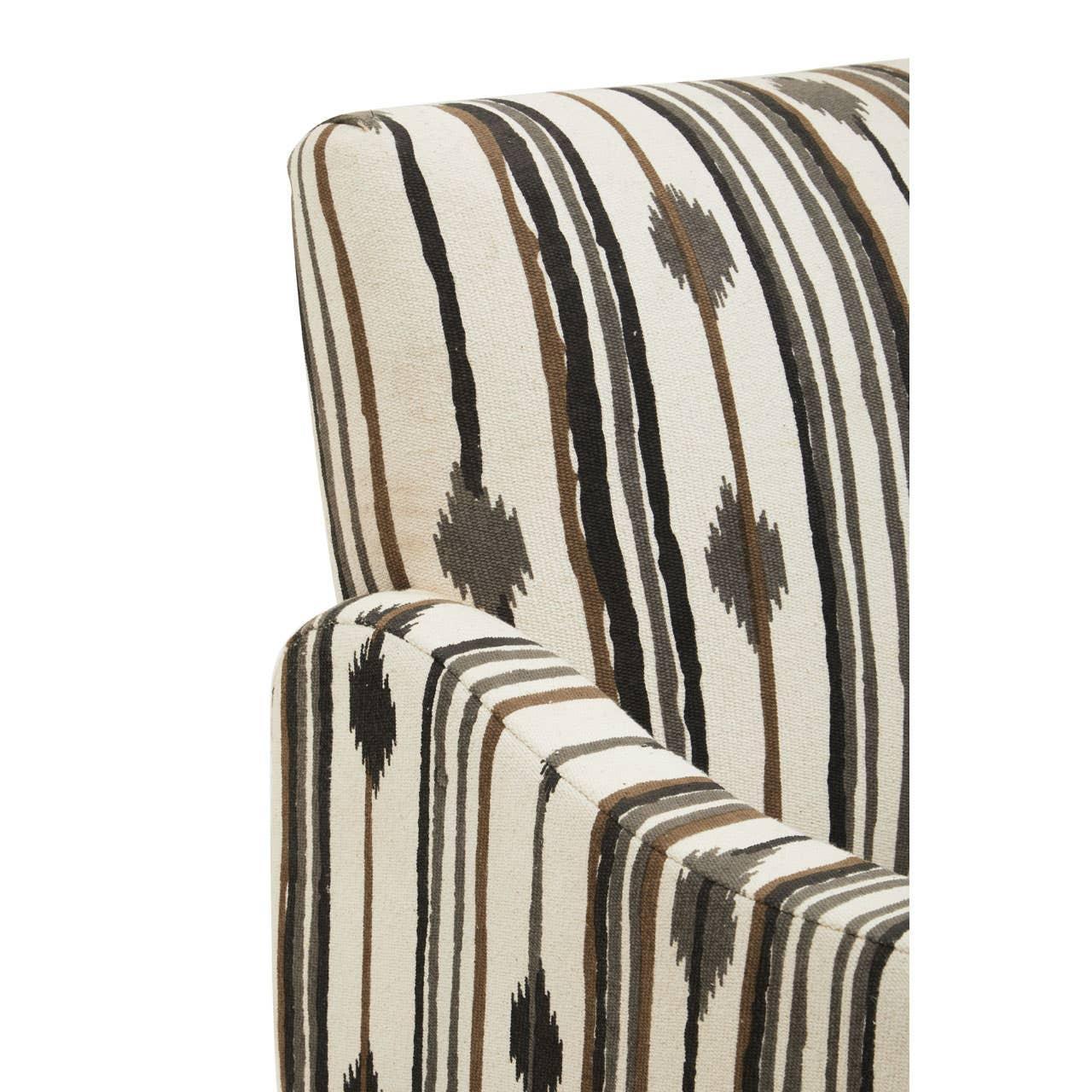Arm and backrest of patterned fabric sofa in cream, brown and black tribal stripes