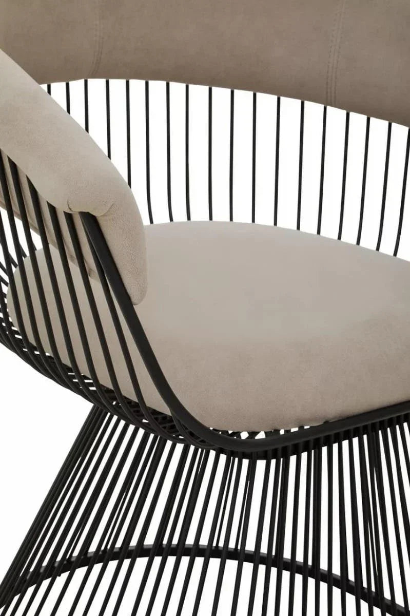 Modern accent chair with beige cushion and black metal frame, close-up of seat and armrest