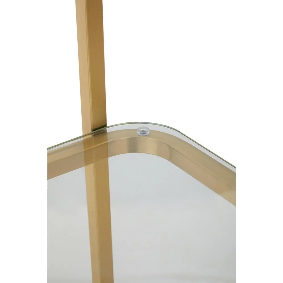 Corner of a glass coffee table with gold metal frame detail