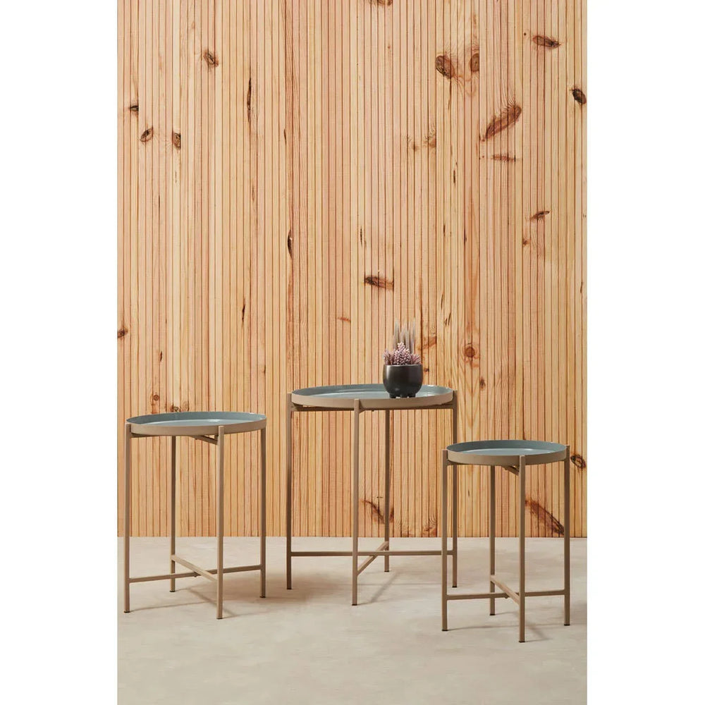 Set of three round metal nesting tables with grey tops and gold frames, indoor setting