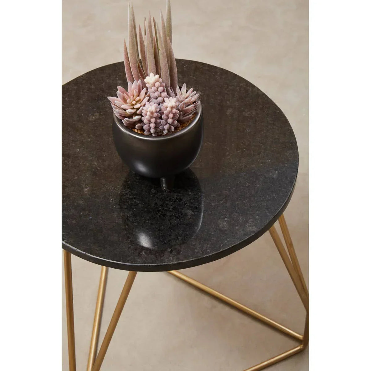 round black marble side table with gold legs and potted faux succulents on top