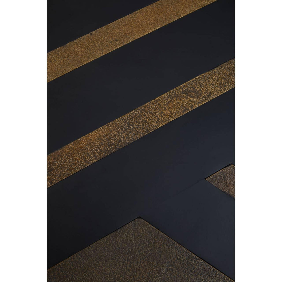 Close-up of black and gold dining table top with textured metallic finish and geometric lines