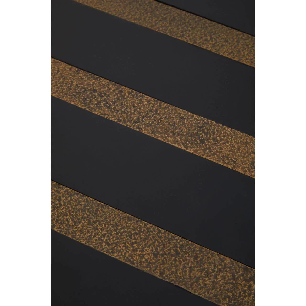 Close-up of black metal table top with gold textured stripe detail