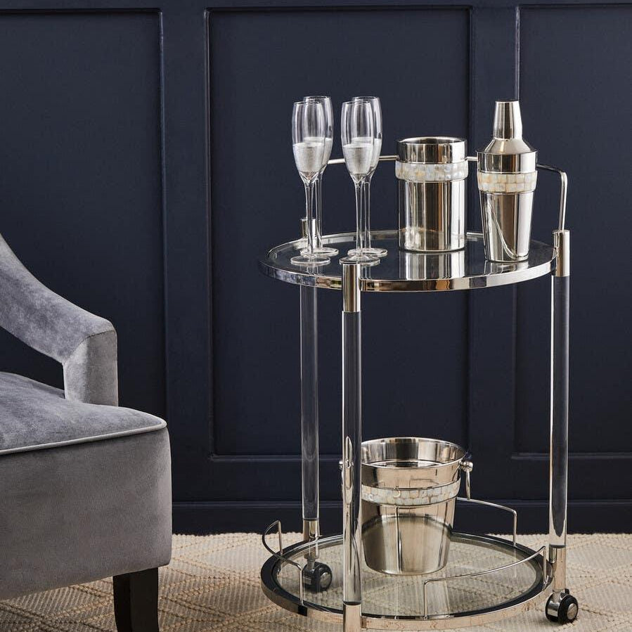 Chrome drinks trolley with glass shelves, champagne flutes, ice bucket and cocktail shaker