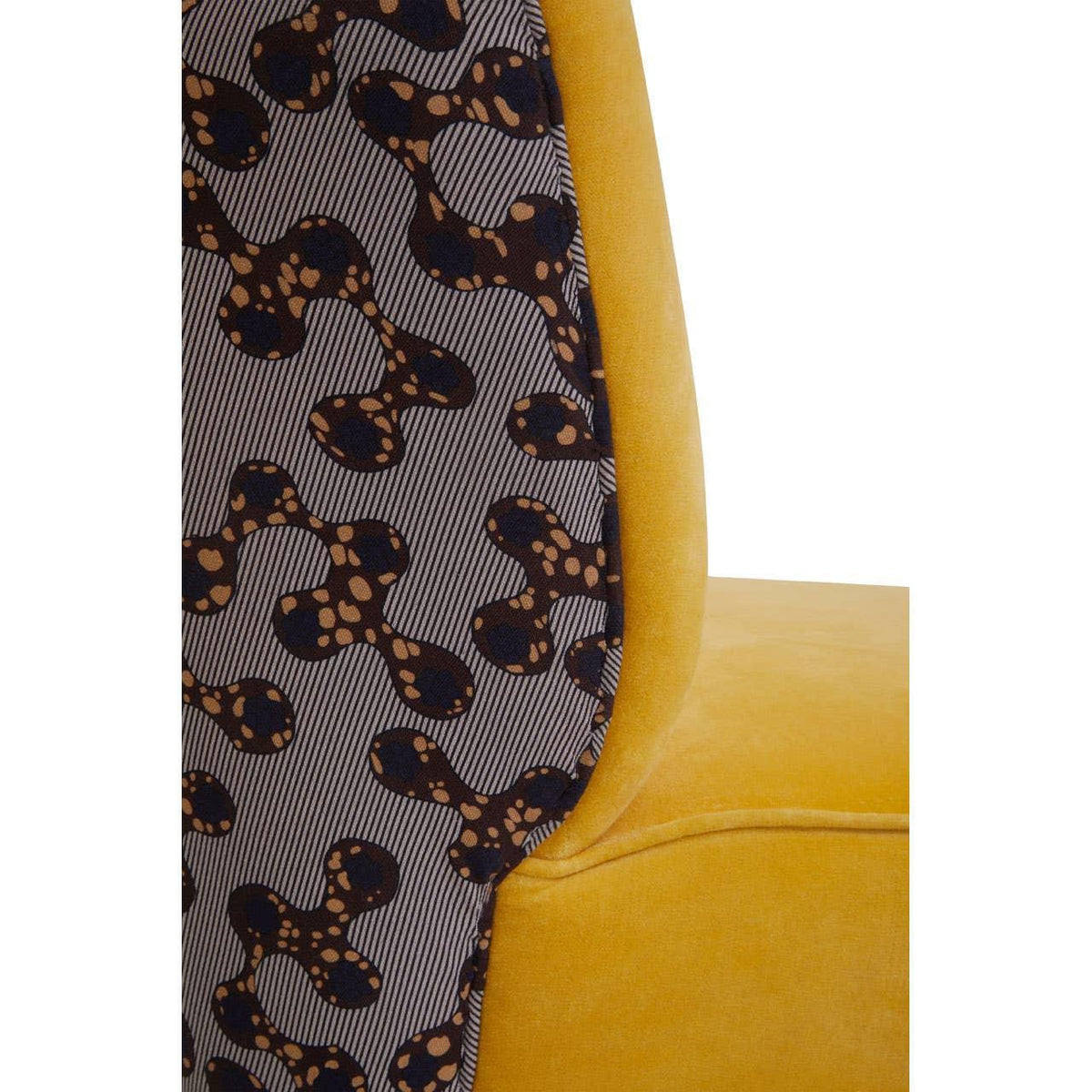 Yellow velvet chair closeup with patterned fabric backrest and modern upholstery detail