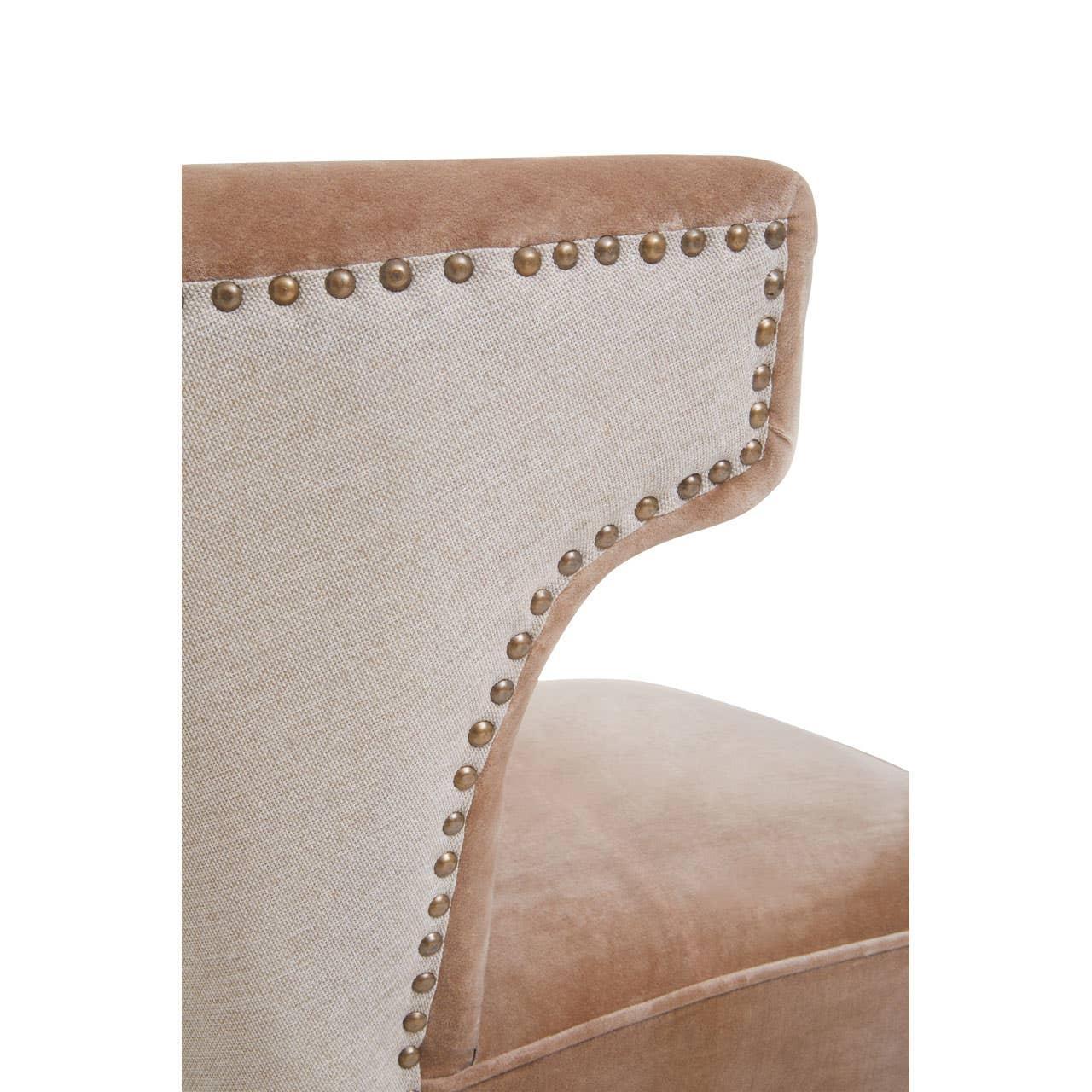 Beige upholstered chair backrest with bronze stud detailing and velvet fabric edge