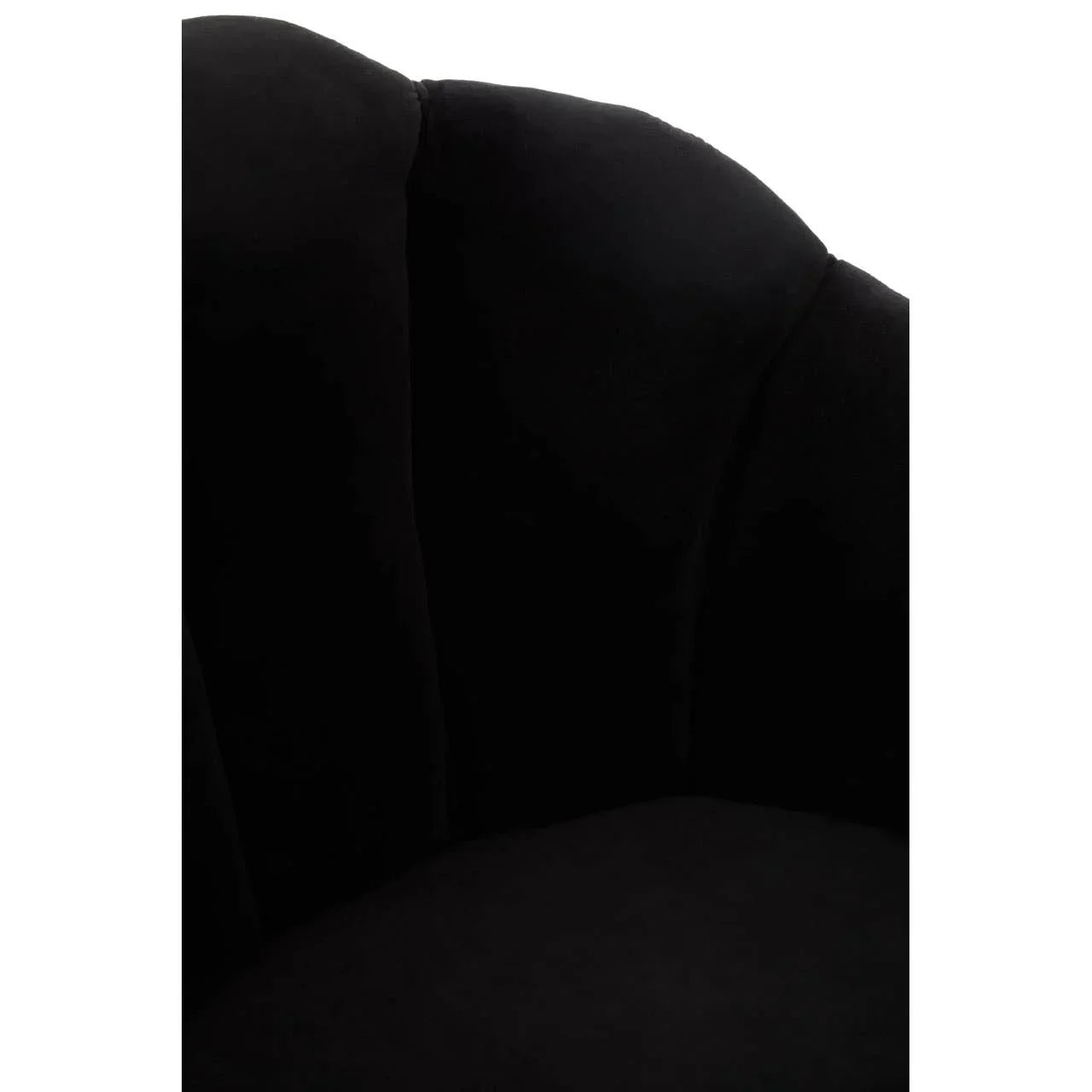 Closeup of black velvet accent chair with scalloped backrest upholstery