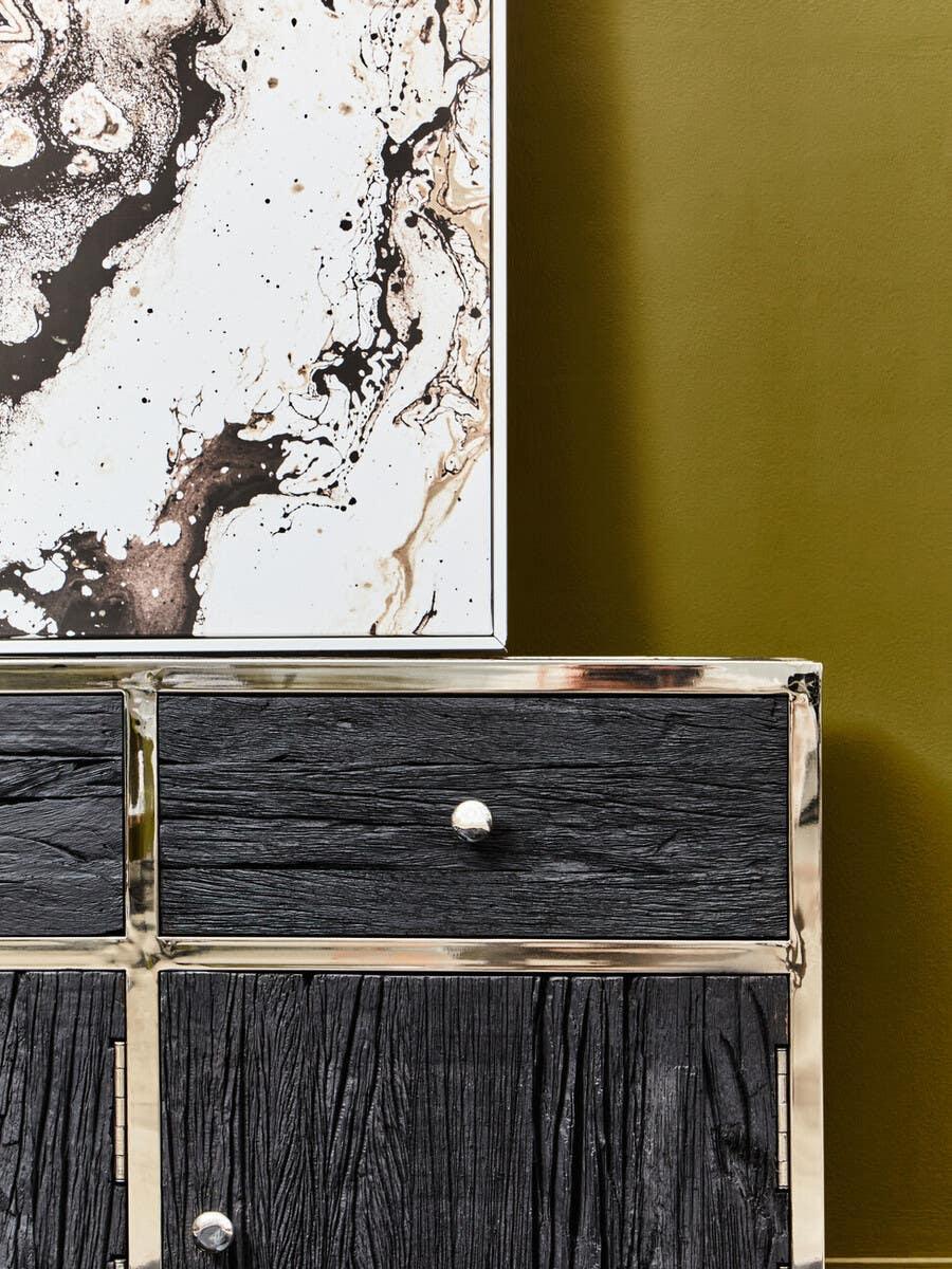 Black wood sideboard with gold frame and drawer front against olive green wall