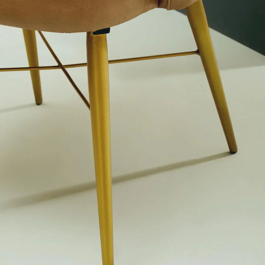 Tan leather chair with slim gold metal legs, close-up on upholstery and modern frame
