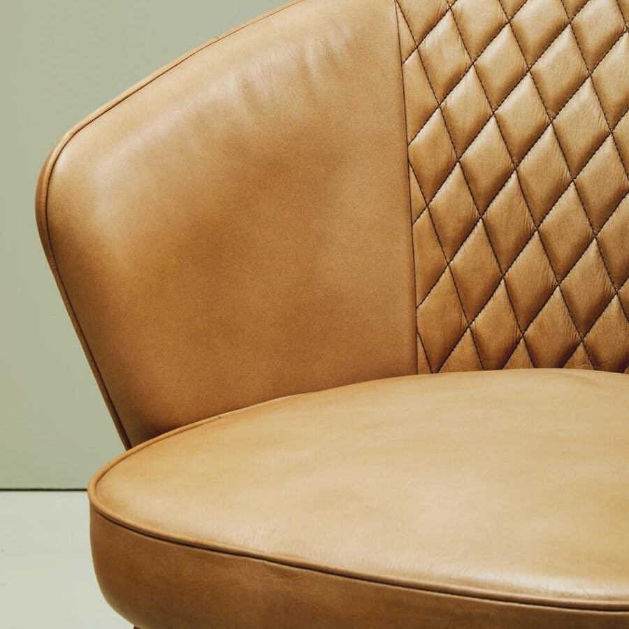 Tan leather dining chair with quilted backrest and smooth seat detail