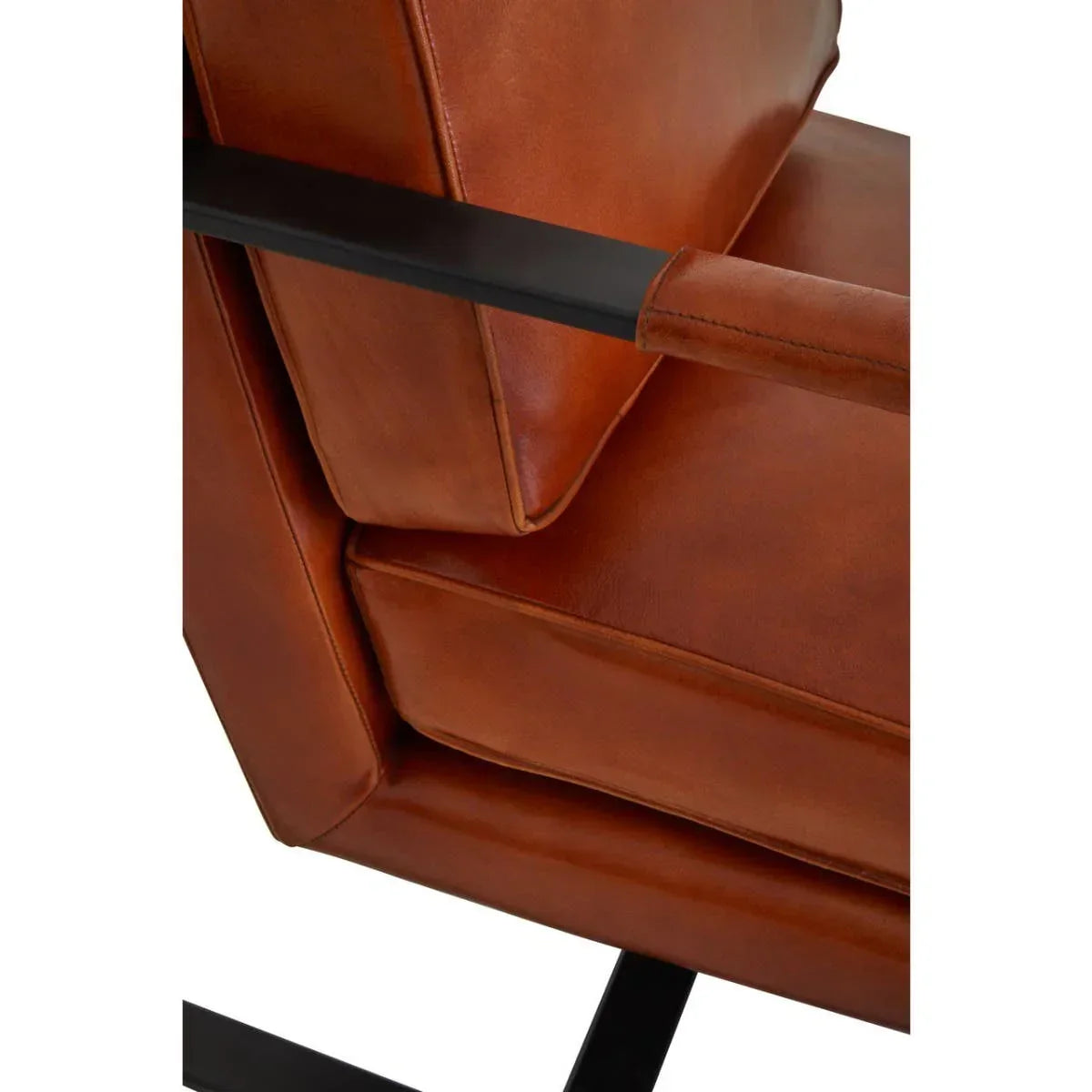 Brown leather armchair cushion and black metal armrest close-up