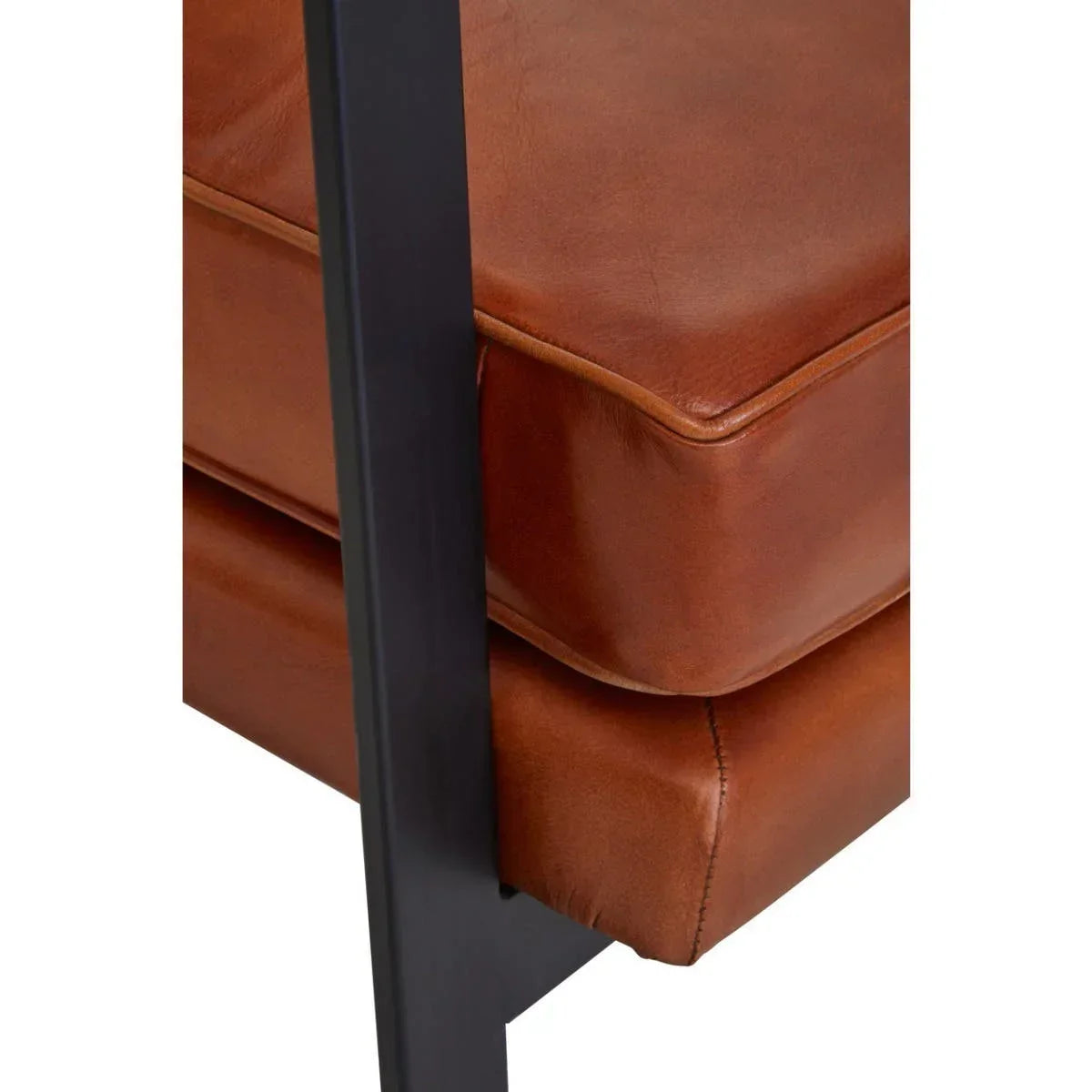 Close-up of brown leather sofa cushion with black metal frame detail