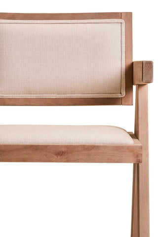Light wood dining chair with cream upholstered seat and backrest, partial side view