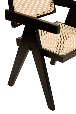 Black wood accent chair with cane seat and backrest, close-up of arm and legs