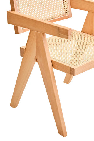 Natural wood dining chair with woven cane seat and back, close-up of angled leg design