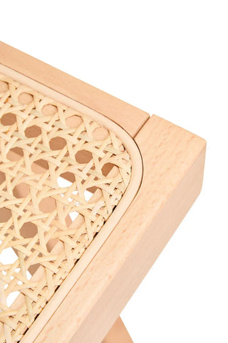 Close-up of light wood furniture with woven rattan seat corner detail