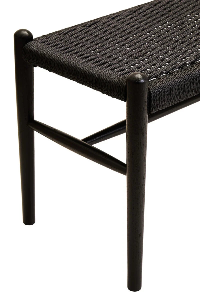 Black woven bench seat with dark wooden frame, close-up on corner and legs