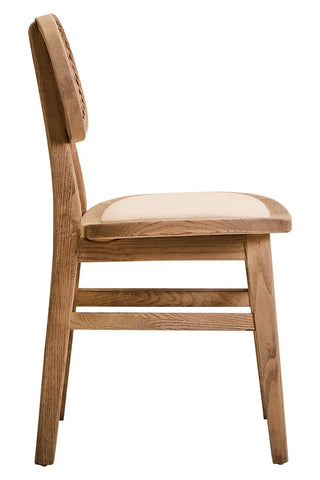 Side view of wooden dining chair with beige cushioned seat and carved backrest