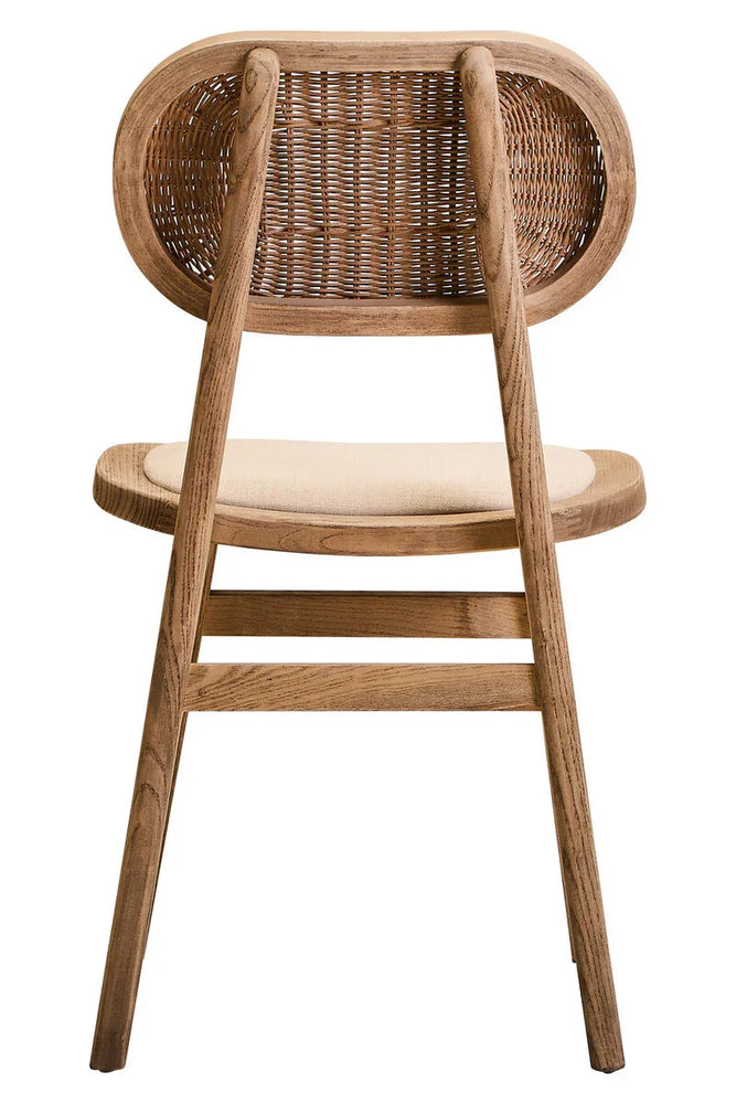 Back view of wooden dining chair with woven rattan backrest and cushioned seat
