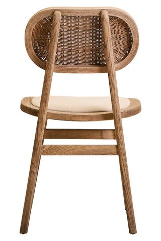 Back view of wooden dining chair with woven rattan backrest and cushioned seat
