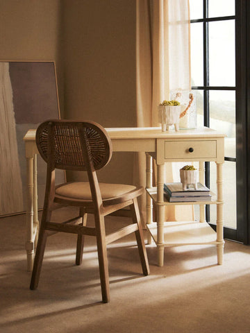 Cream writing desk with drawer and open shelf, paired with a wooden rattan chair